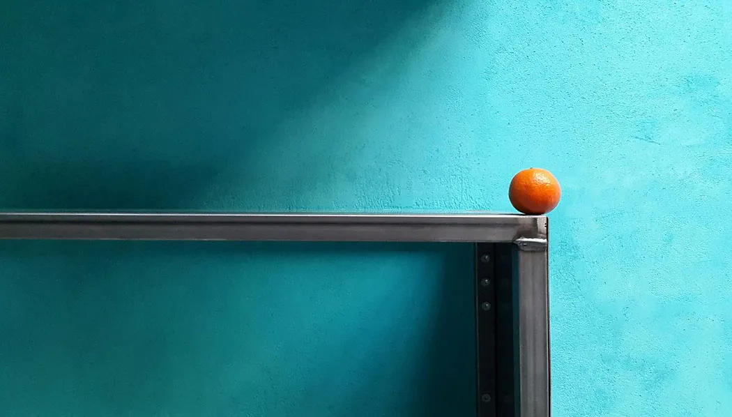 Wandfläche in gespachteltem Edelputz mit Stahlrahmen und einer Mandarine